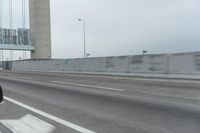 a photo of a highway with a building in the background and a man riding a bicycle