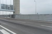 a photo of a highway with a building in the background and a man riding a bicycle