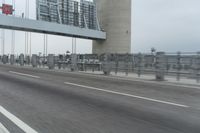 a photo of a highway with a building in the background and a man riding a bicycle