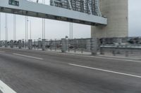 a photo of a highway with a building in the background and a man riding a bicycle