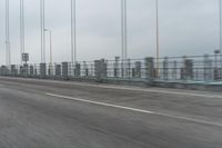 a photo of a highway with a building in the background and a man riding a bicycle