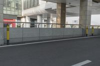 white arrows painted on the side of an empty road next to tall buildings, viewed out of a moving car window