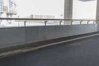 white arrows painted on the side of an empty road next to tall buildings, viewed out of a moving car window