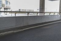 white arrows painted on the side of an empty road next to tall buildings, viewed out of a moving car window