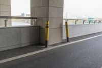 white arrows painted on the side of an empty road next to tall buildings, viewed out of a moving car window
