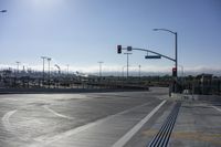 empty street and two rows of benches at a crosswalk intersection under traffic lights at an intersection