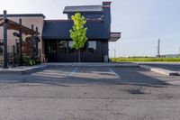 an empty restaurant in the parking lot outside of a building with awning and awnings