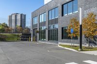 a parking lot next to a building with tall buildings and trees in the background,