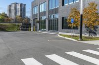 a parking lot next to a building with tall buildings and trees in the background,