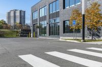 a parking lot next to a building with tall buildings and trees in the background,