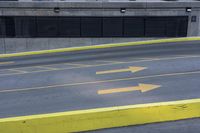 some yellow arrows are in the pavement pointing to left, and to right, on a sidewalk in front of some buildings