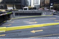 some yellow arrows are in the pavement pointing to left, and to right, on a sidewalk in front of some buildings