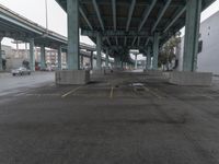 an empty parking lot with a lot of parked cars underneath it with overpasses