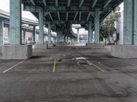 an empty parking lot with a lot of parked cars underneath it with overpasses