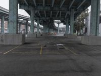 an empty parking lot with a lot of parked cars underneath it with overpasses