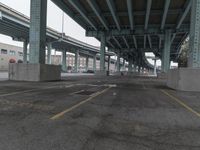 an empty parking lot with a lot of parked cars underneath it with overpasses