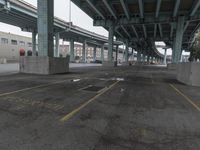 an empty parking lot with a lot of parked cars underneath it with overpasses