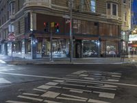 a city street at night with an empty pedestrian crosswalk lit up by the light of a stoplight