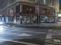 a city street at night with an empty pedestrian crosswalk lit up by the light of a stoplight