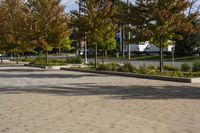 a city area with trees and paved concrete in the foreground with blue sky and sun