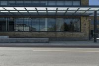 a street view from the corner of a building with glass windows looking in to an entrance