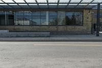 a street view from the corner of a building with glass windows looking in to an entrance