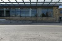 a street view from the corner of a building with glass windows looking in to an entrance