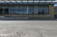 a street view from the corner of a building with glass windows looking in to an entrance