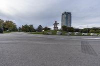 the skateboarder is going down the street near the water tower with rocks in it