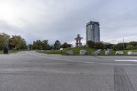 the skateboarder is going down the street near the water tower with rocks in it