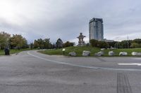 the skateboarder is going down the street near the water tower with rocks in it