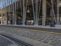 this is a train tracks and a bus station in an urban setting at dusk with the building visible