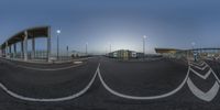 the view of some train tracks and an airport from the street at night time, with multiple traffic lights