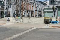 an intersection with a building in the background and a sign for an entrance is on display at the corner