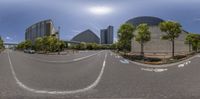 a 360 - view photo of an intersection of a road and tall buildings in the distance