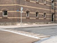 stop signs are shown at an intersection next to a building on the side of an old brick road