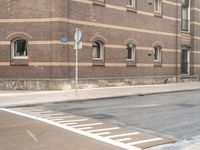 stop signs are shown at an intersection next to a building on the side of an old brick road