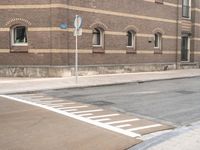 stop signs are shown at an intersection next to a building on the side of an old brick road