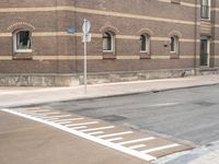 stop signs are shown at an intersection next to a building on the side of an old brick road