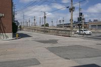 a police car is stopped at the intersection of a street that leads to the bridge