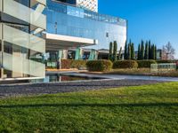 an outdoor bench on the side of a building, with a very large glass building in the background