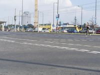 two men are riding bikes along a street with vehicles around it and people crossing the road