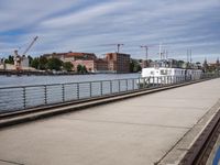 the road has many rails along it that lead out to the harbor while there is a bridge