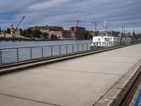 the road has many rails along it that lead out to the harbor while there is a bridge