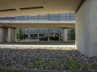 a large parking garage with large rocks in the front and grass below it and grass