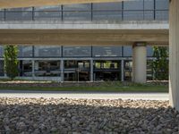 a large parking garage with large rocks in the front and grass below it and grass