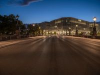 the city skyline is at night from the street level with traffic and pedestrians walking on it