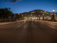 the city skyline is at night from the street level with traffic and pedestrians walking on it