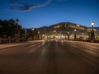 the city skyline is at night from the street level with traffic and pedestrians walking on it