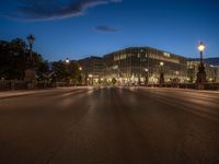 the city skyline is at night from the street level with traffic and pedestrians walking on it